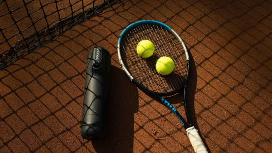 Bounce Tube on a Tennis Court with a tennis racket and tennis balls